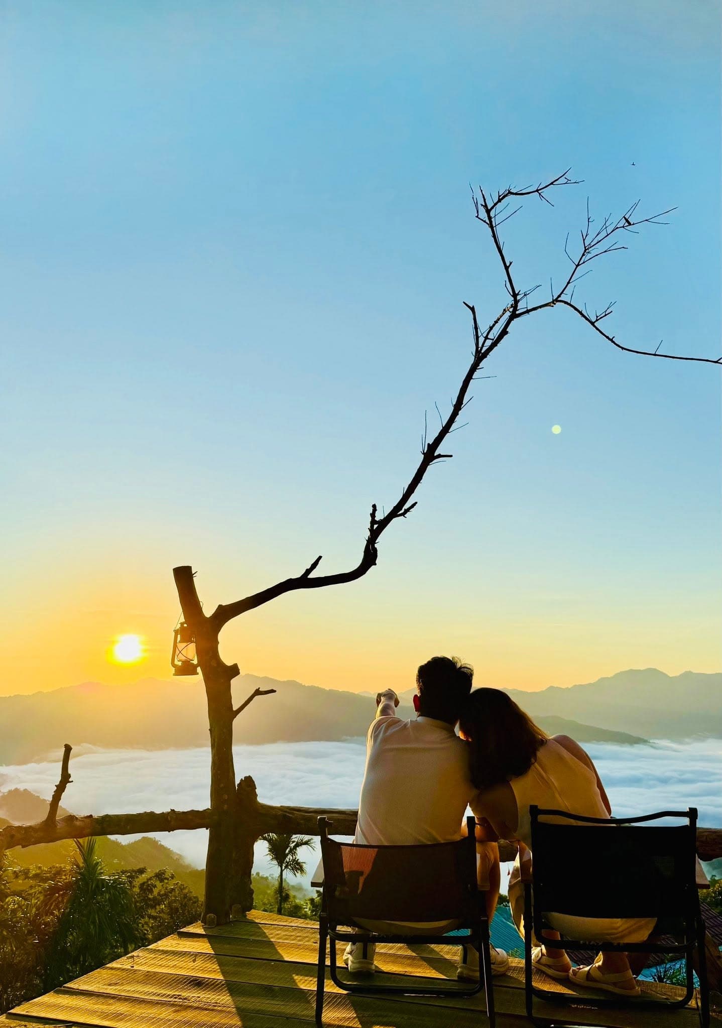 Đôi bạn trẻ ngồi tựa vai ngắm bình minh trên biển mây