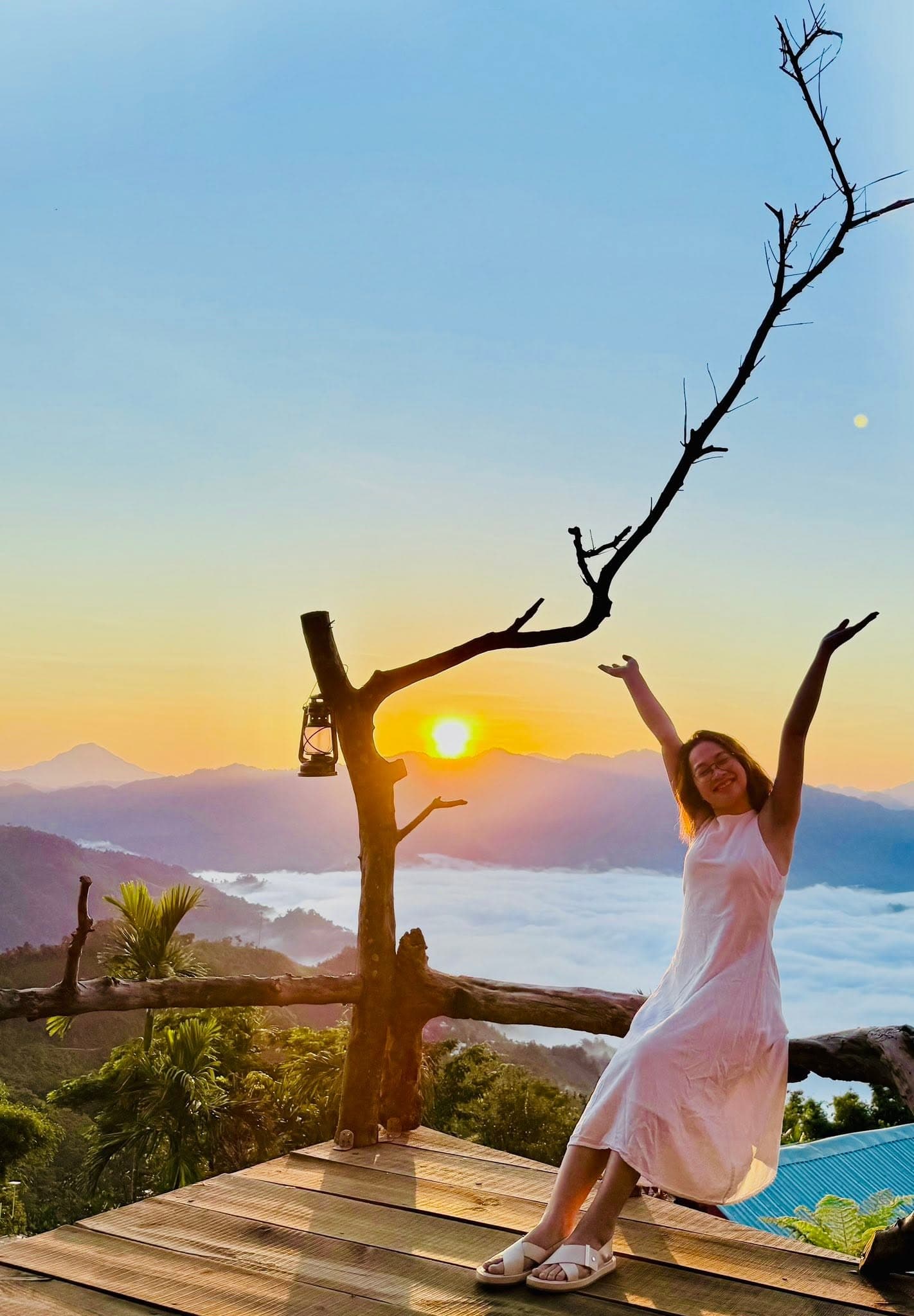 Cô gái váy trắng tay giơ cao đón nắng sớm trên biển mây