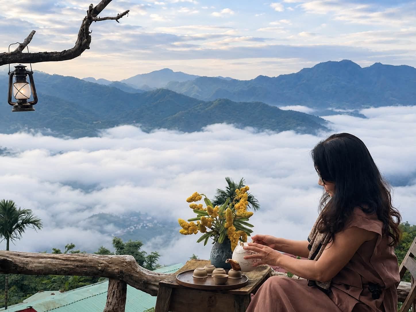 Khách rót trà bên hoa vàng, ngắm biển mây trải dài trên núi