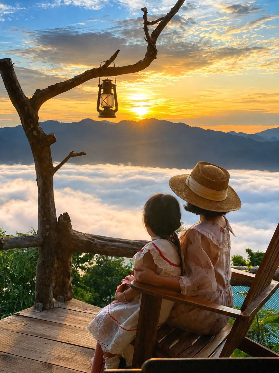 Mẹ con ôm nhau ngắm mặt trời lặn trên biển mây