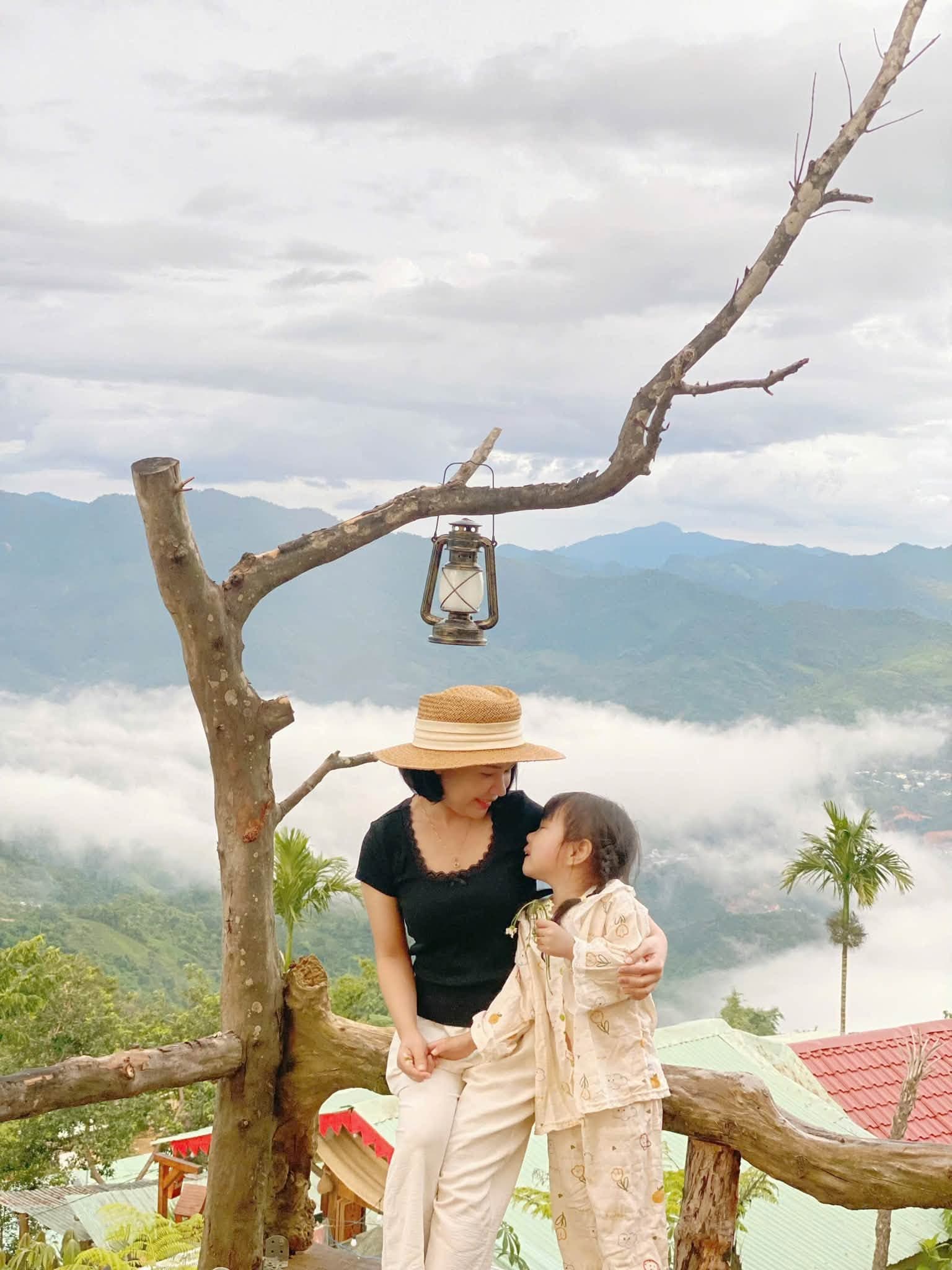 Mẹ và con gái âu yếm bên đèn lồng, biển mây phía sau